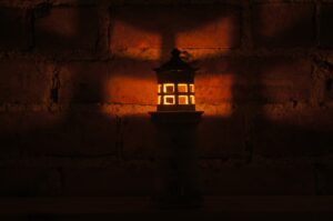 Small handmade ceramic lighthouse candle lit